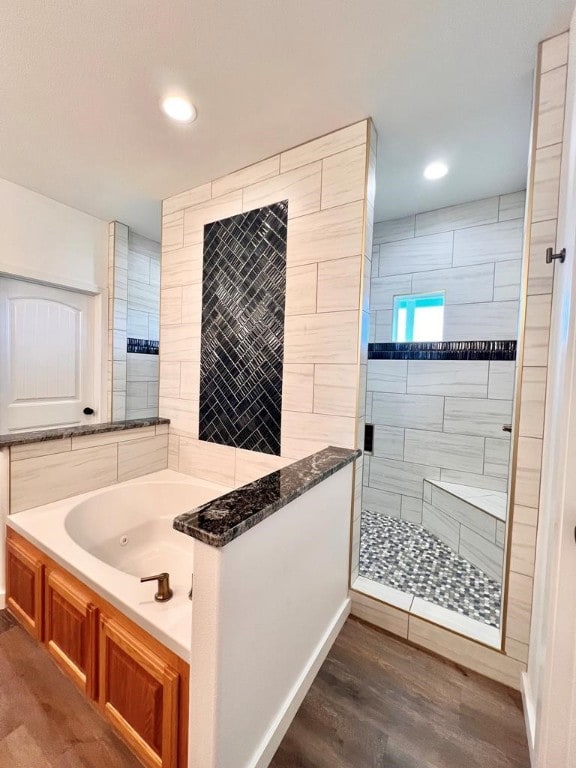 bathroom with hardwood / wood-style floors and independent shower and bath