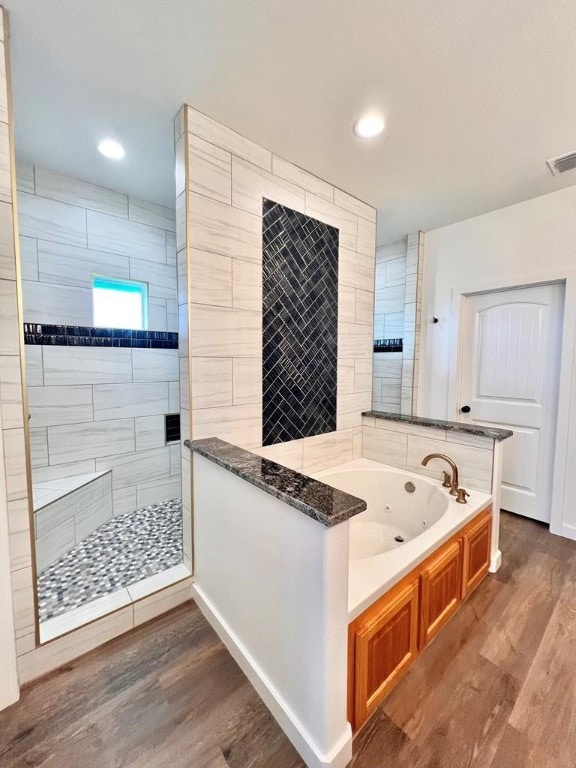 bathroom with shower with separate bathtub and wood-type flooring