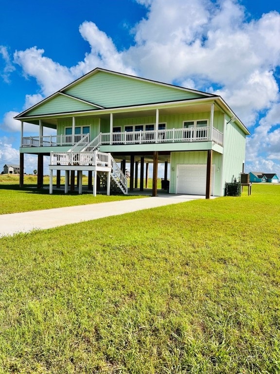 back of house featuring a garage, a yard, and covered porch