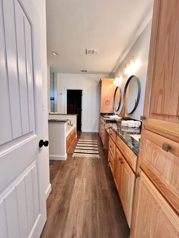 bathroom featuring a tub to relax in, vanity, and hardwood / wood-style floors