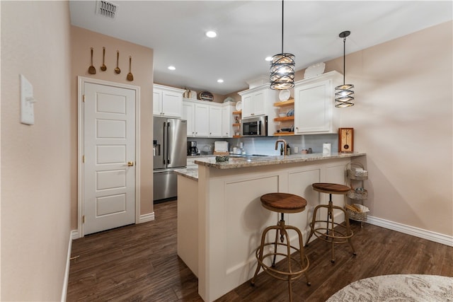 kitchen featuring white cabinetry, kitchen peninsula, stainless steel appliances, and decorative light fixtures