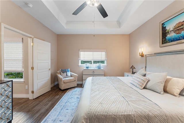 bedroom featuring dark wood-type flooring, ceiling fan, and a raised ceiling