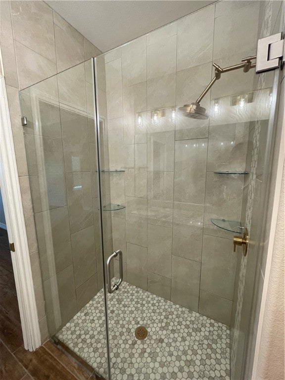 bathroom featuring an enclosed shower and wood-type flooring