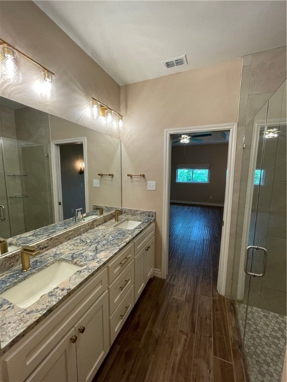 bathroom featuring walk in shower, vanity, and hardwood / wood-style floors