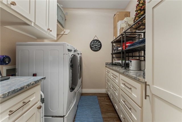 laundry room with dark wood-type flooring, cabinets, and washer and dryer