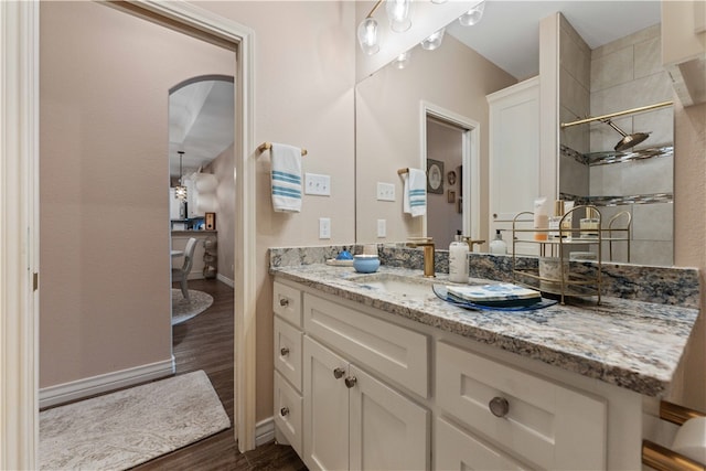 bathroom featuring hardwood / wood-style flooring, vanity, and walk in shower