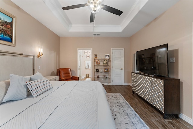 bedroom with dark hardwood / wood-style flooring, a tray ceiling, ceiling fan, and crown molding