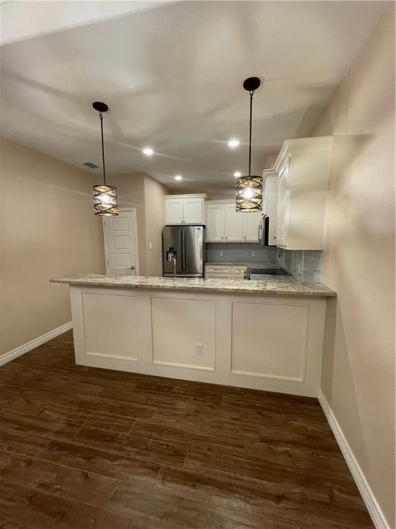 kitchen with stainless steel appliances, hanging light fixtures, dark wood-type flooring, and kitchen peninsula