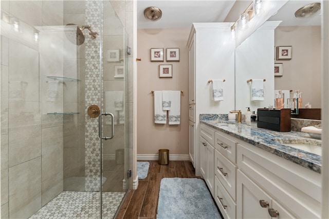 bathroom featuring hardwood / wood-style floors, walk in shower, and vanity