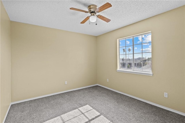 carpeted spare room featuring a textured ceiling, baseboards, and ceiling fan