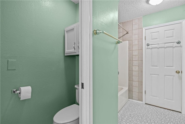 bathroom with tile patterned flooring, shower / washtub combination, a textured wall, toilet, and a textured ceiling
