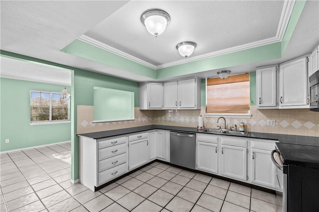 kitchen with dark countertops, appliances with stainless steel finishes, a sink, and white cabinetry