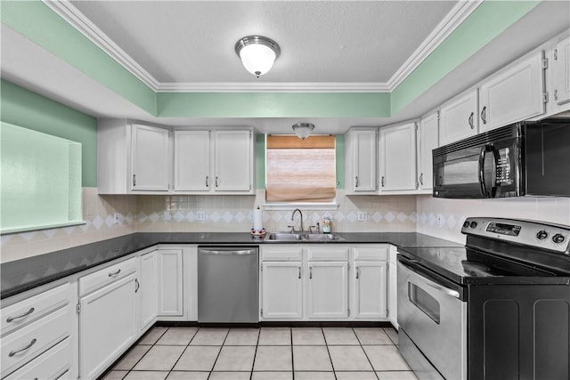 kitchen featuring white cabinets, dark countertops, stainless steel appliances, and a sink