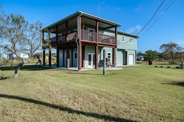 rear view of house featuring a lawn, a patio area, a garage, and a wooden deck