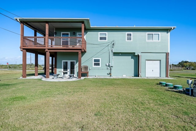 back of house with a yard, a patio, and a garage