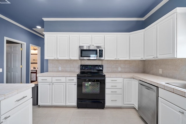 kitchen featuring crown molding, white cabinets, and stainless steel appliances