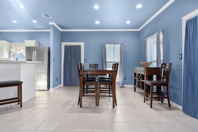 dining space with plenty of natural light, light tile patterned flooring, and crown molding