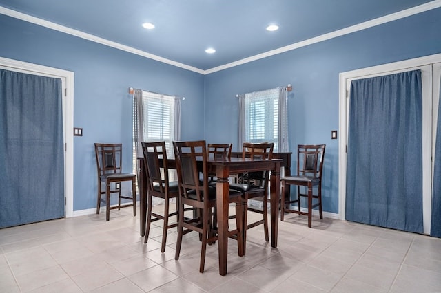 dining room featuring ornamental molding, a healthy amount of sunlight, and light tile patterned flooring