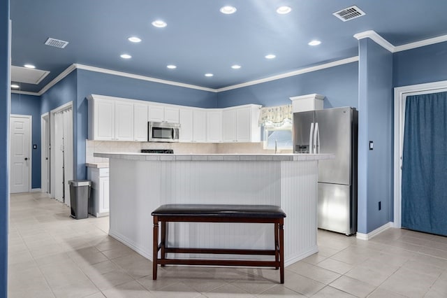 kitchen with white cabinets, stainless steel appliances, and a kitchen island