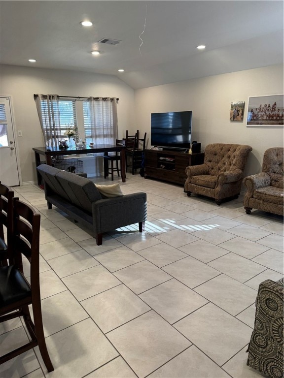 living room with light tile patterned flooring and vaulted ceiling