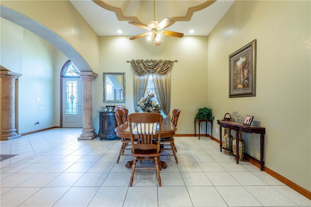 dining room with ornate columns, a towering ceiling, light tile patterned flooring, and ceiling fan