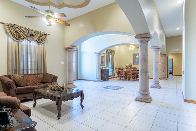 living room featuring light tile patterned flooring, ceiling fan, and decorative columns