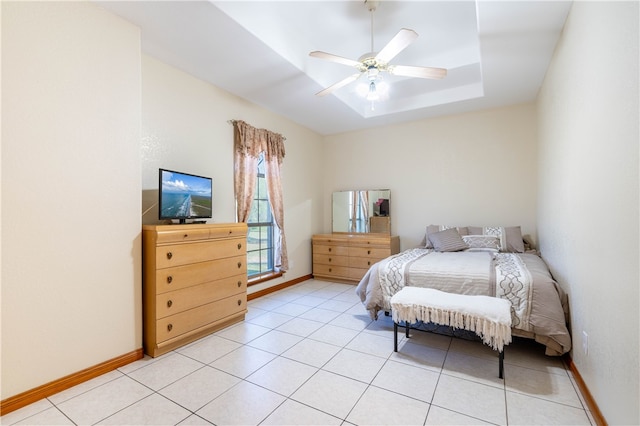 bedroom featuring light tile patterned floors, ceiling fan, and a raised ceiling