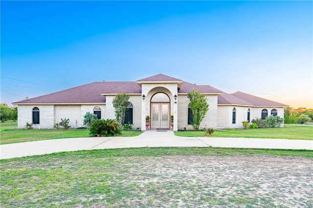 mediterranean / spanish-style house with a yard