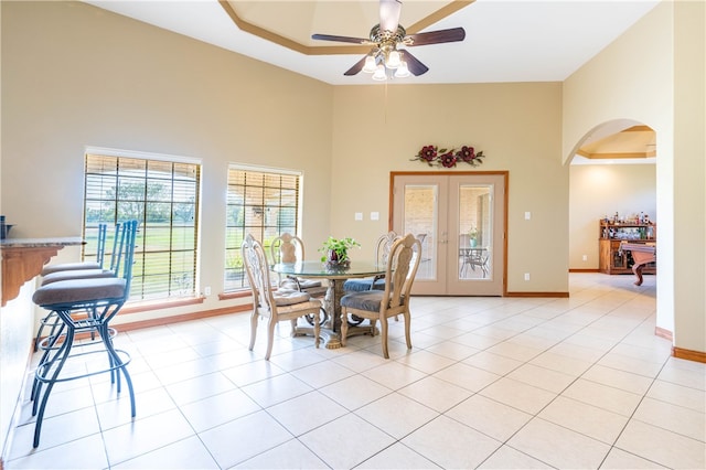 dining area featuring a high ceiling, ceiling fan, and light tile patterned flooring