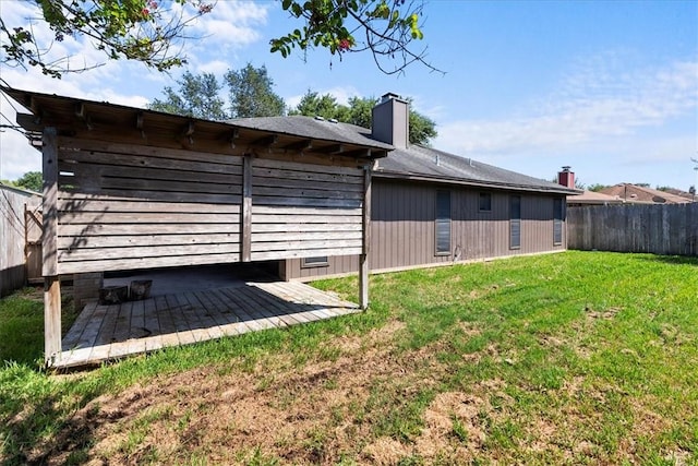 rear view of property featuring a patio area, a lawn, a chimney, and fence