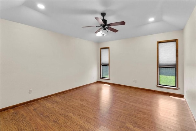 unfurnished room featuring a ceiling fan, vaulted ceiling, baseboards, and wood finished floors