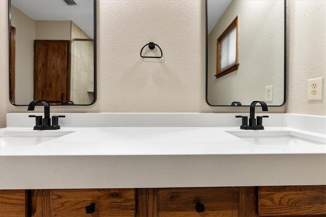 bathroom featuring a textured wall and vanity