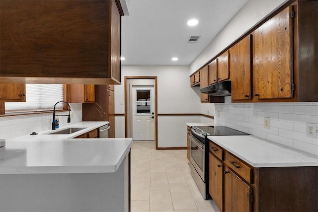 kitchen with visible vents, light countertops, appliances with stainless steel finishes, a sink, and under cabinet range hood