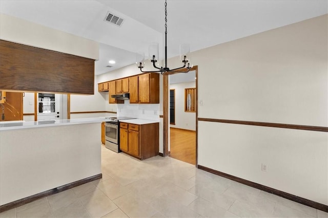 kitchen with visible vents, stainless steel electric range oven, brown cabinets, light countertops, and a chandelier