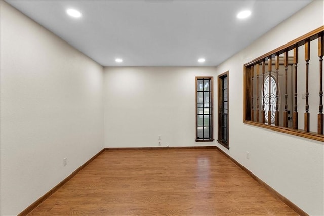 empty room featuring recessed lighting, wood finished floors, and baseboards