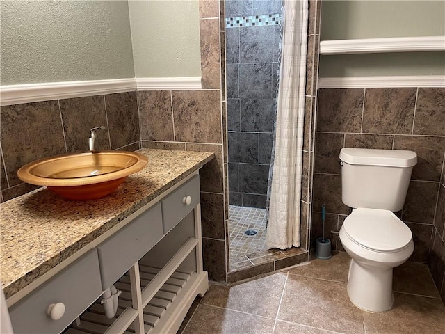 full bathroom featuring vanity, a shower stall, toilet, and tile walls