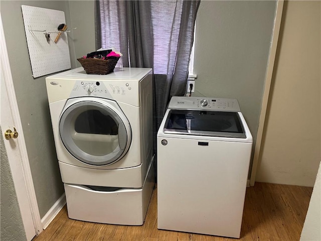 washroom with laundry area, independent washer and dryer, and light wood-type flooring