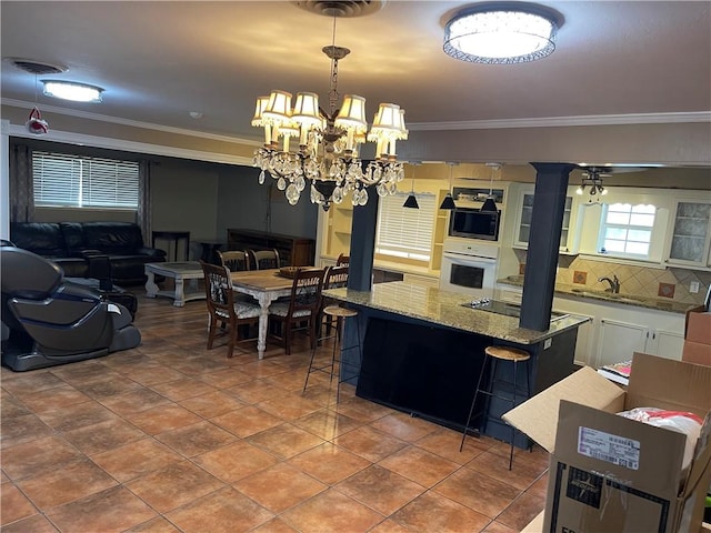 kitchen featuring built in microwave, decorative backsplash, crown molding, white oven, and open floor plan