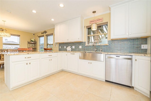 913 Pompano Dr, Aransas Pass, TX 78336 - kitchen with stainless steel dishwasher, a sink, a peninsula, decorative backsplash, and white cabinetry