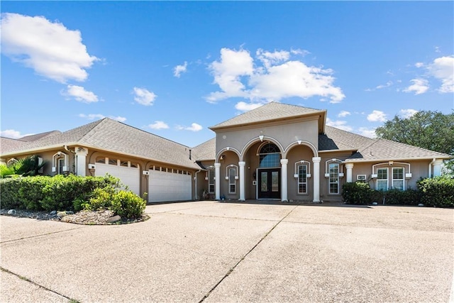 8029 Villefranche Dr, Corpus Christi, TX 78414 - mediterranean / spanish home with french doors, an attached garage, stucco siding, and driveway