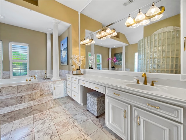 bathroom featuring tiled bath, vanity, and decorative columns