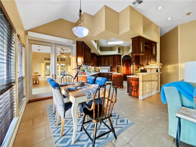 tiled dining area featuring ceiling fan and vaulted ceiling