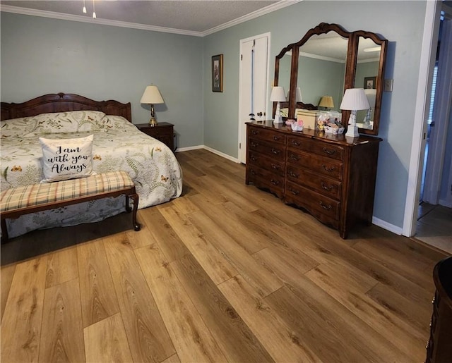 bedroom with crown molding, baseboards, and wood finished floors