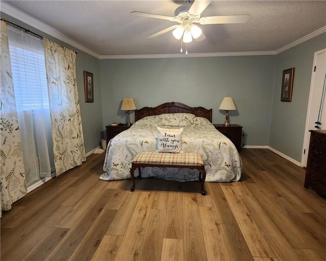 bedroom with baseboards, ceiling fan, ornamental molding, wood finished floors, and a textured ceiling