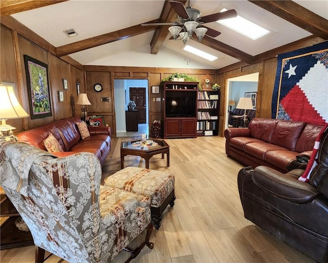 6421 Oakbrook Dr, Corpus Christi, TX 78413 - living room featuring wooden walls, visible vents, a ceiling fan, and vaulted ceiling with skylight