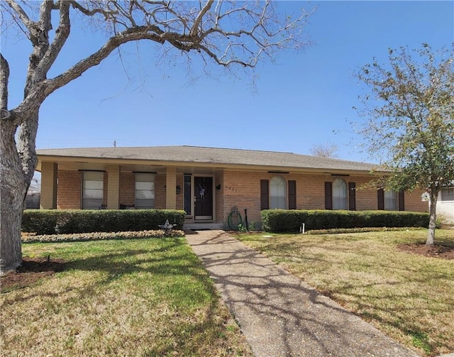 ranch-style home featuring brick siding and a front lawn