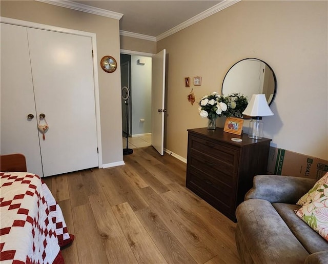 bedroom featuring baseboards, wood finished floors, and crown molding