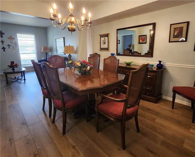 dining space with an inviting chandelier, baseboards, and wood finished floors