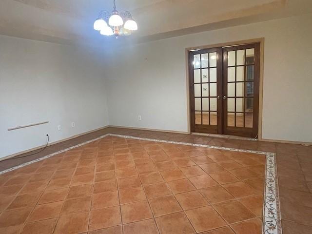 empty room with tile patterned flooring, a chandelier, and french doors