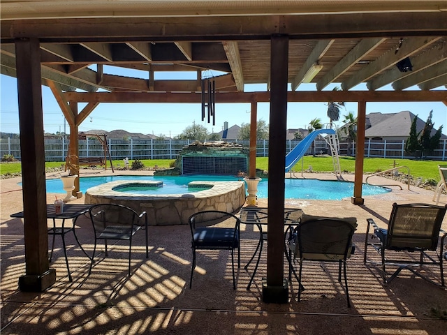 view of swimming pool with a lawn, a water slide, an in ground hot tub, and a patio